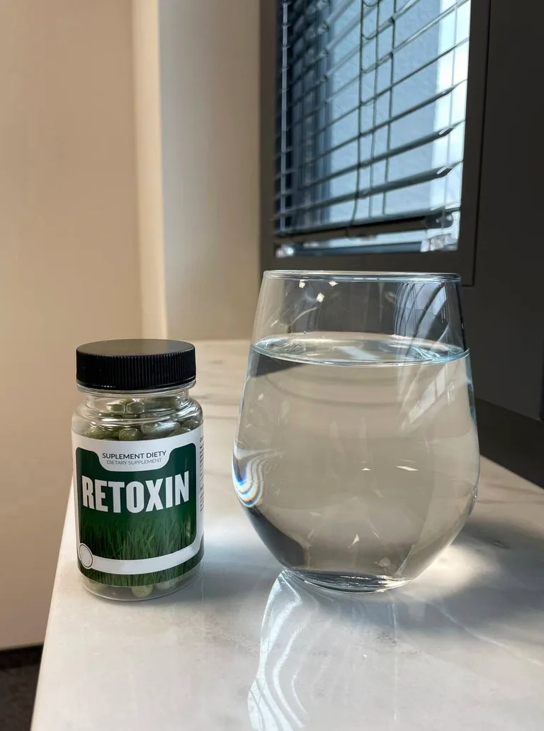 Retoxin obok szklanki wody — kapsułki popija się wodą